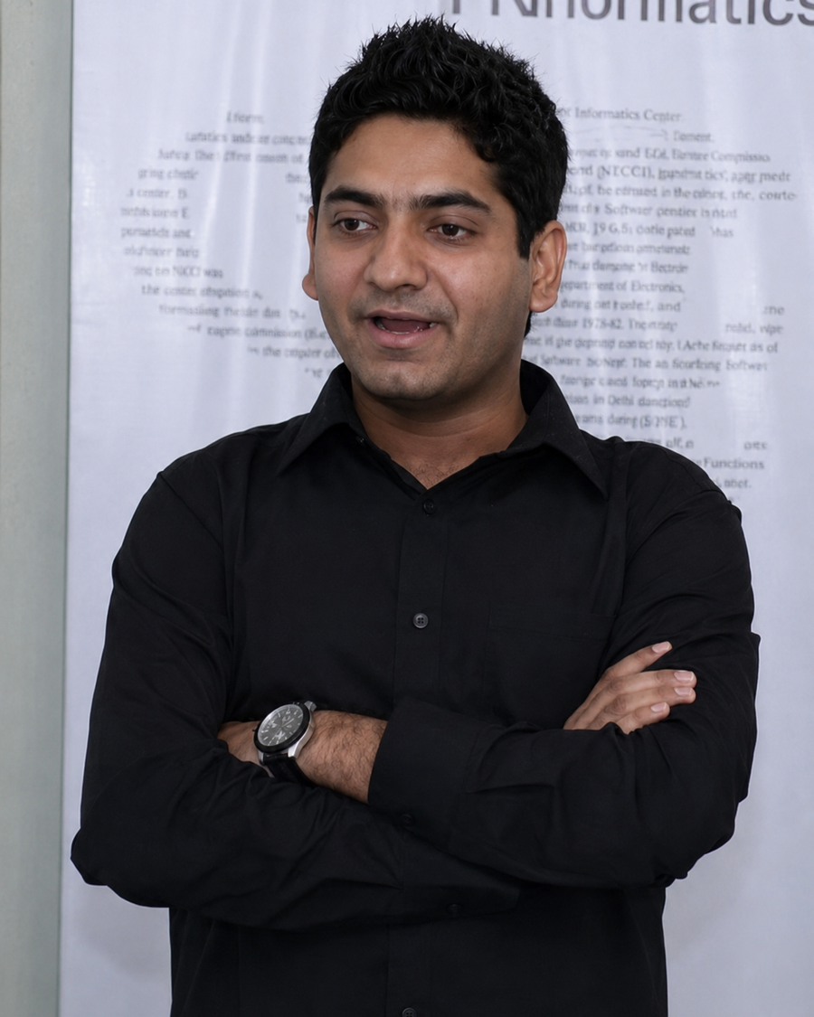Young Vishal Manocha in a black shirt, in front of a report